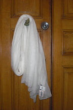 A white cashmere scarf hanging over a parisien wooden door.