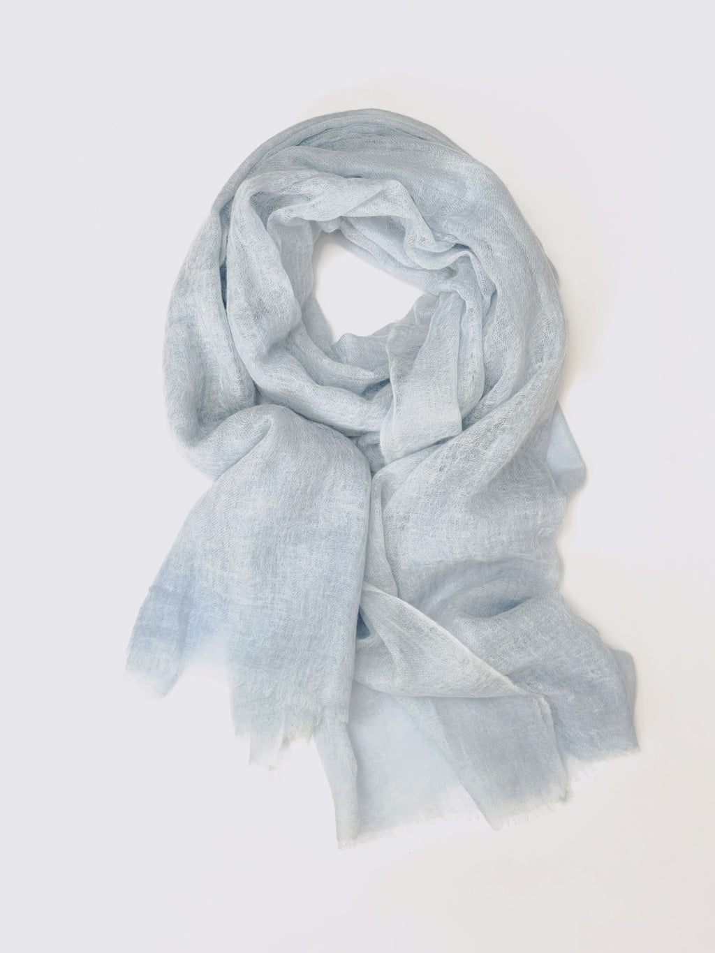 A light blue semi-sheer cashmere scarf with a soft, lightweight texture, draped in a loose loop against a plain white background.
