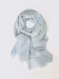 A light blue semi-sheer cashmere scarf with a soft, lightweight texture, draped in a loose loop against a plain white background.